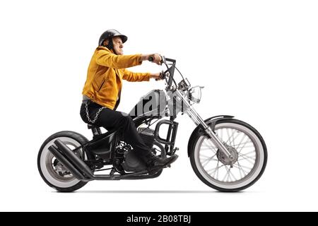 Älterer Mann in einer gelben Lederjacke, der ein schwarzes, individuelles Motorrad auf weißem Hintergrund reitet Stockfoto