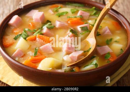 Langsam gekochte, gespaltene Erbsensuppe mit Gemüse und Schinken in einer Schüssel auf dem Tisch. Horizontal Stockfoto