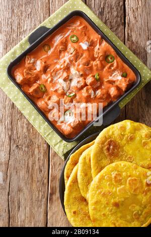 Tofu-Butter Masala in einer würzigen Tomatensauce mit Cashew, Knoblauch und Ingwer serviert mit Roti-Nahaufnahme in einer Pfanne auf dem Tisch. Vertikale Draufsicht von oben Stockfoto