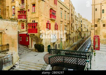 Valletta, Malta - 18. Februar 2019: Bunte alte traditionelle maltesische Balkone in Valletta. Straße am Abend Stockfoto