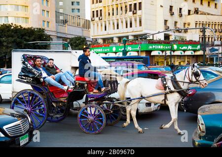 Touristen in einer Pferdekutsche stecken im Abendverkehr auf dem Tahrir-Platz in Kairo, Ägypten Stockfoto