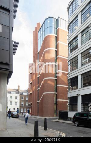 Breite Ansicht der gebogenen Ecke aus Backstein. UCLH Eye Hospital, London, Großbritannien. Architekt: Pilbrow und Partner, 2019. Stockfoto