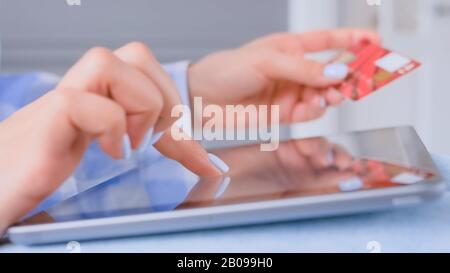 Online-Shopping - Frau mit Tablet und roter Kreditkarte - Nahansicht Stockfoto