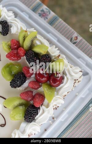 Biskuitkuchen mit Brombeeren, Himbeeren, Kiwi, Kirschen. Stockfoto