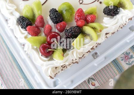 Biskuitkuchen mit Brombeeren, Himbeeren, Kiwi, Kirschen. Stockfoto