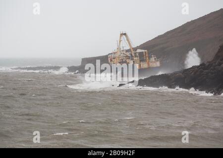 Cork, Irland. Feb. 2020. Atlas Cargo Ship, Ballyanna, Cork City Das Schiff von der gegenüberliegenden Landzunge aus gesehen. Atlas-Cargo-Schiff an der Küste von Ballycotton, östlich von Ballyanna, aufgespült. Viele Zuschauer machten sich auf den Weg durch Felder und steile Hänge, um das Wrack selbst zu sehen, einige kamen sogar zu einem genaueren Blick, stiegen die provisorische Leiter hinauf und erkundeten das Schiffsdeck trotz starker Winde und Regen. Credit: Damian Coleman/Alamy Live News Stockfoto