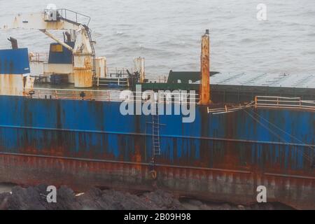 Cork, Irland. Feb. 2020. Atlas Cargo Ship, Ballyanna, Cork City EIN Mann, der sich den steilen Hang hinunter zum Boden machte und den provisorischen lader auf das Deck klimte. Atlas-Cargo-Schiff an der Küste von Ballycotton, östlich von Ballyanna, aufgespült. Viele Zuschauer machten sich auf den Weg durch Felder und steile Hänge, um das Wrack selbst zu sehen, einige kamen sogar zu einem genaueren Blick, stiegen die provisorische Leiter hinauf und erkundeten das Schiffsdeck trotz starker Winde und Regen. Credit: Damian Coleman/Alamy Live News Stockfoto