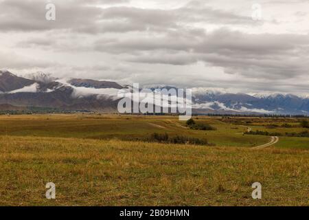 Bewölkter Himmel und niedrige Wolken in den Bergen von Kirgisistan, dem Nordufer des Issyk-Kul-Sees Stockfoto