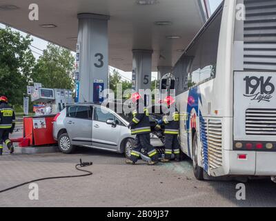 Otwock, Polen - 30. Mai 2018: Feuerwehrleute ziehen ein Auto heraus, das in einen Benzinverteiler an einer Tankstelle lief. Stockfoto