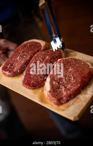 Frische rohe Prime Black Angus Rindfleisch Steaks auf Holzbrett: Filet, Denver Cut, Roastbeef, Rib-Eye Stockfoto