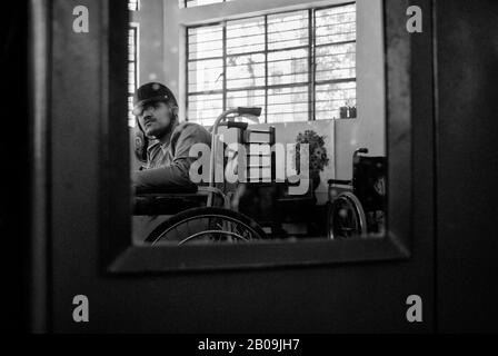 Ein Spiegel an der Tür eines Schranks reflektiert Zubin, einen der Jungen, der am schlimmsten von Der Zerebralen Palisie betroffen ist. Parents Association of Persons with Cerebral Palsy and Associated Disorders (PAPCP) in Bangalore, Indien. Januar 2009. Eines der Bilder aus der Fotogeschichte Cerebral Palsy von Ayush Ranka. Stockfoto