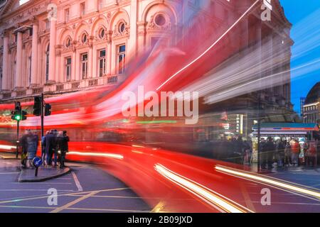 West End, London, Großbritannien. Feb. 2020. Ein roter Doppeldeckerbus verlässt leichte Wege auf Regen, der vom Piccadilly Circus durchnässt wird. Touristen und Londoner machen an einem nassen, aber milden Tag im Londoner West End die meisten kurzen Regenlücken. Kredit: Imageplotter/Alamy Live News Stockfoto