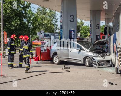 Otwock, Polen - 30. Mai 2018: Feuerwehrleute ziehen ein Auto heraus, das in einen Benzinverteiler an einer Tankstelle lief. Stockfoto