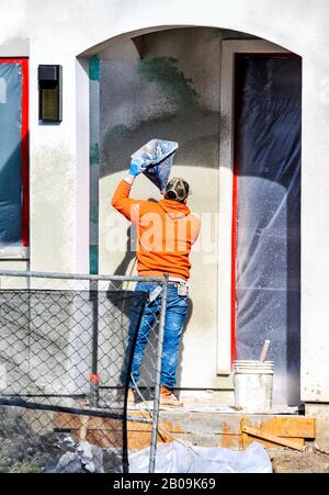 Bauarbeiter setzen dekorativen Putz auf das Äußere des Hauses Stockfoto