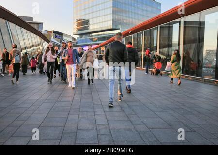 Menschen und Käufer, die zum Westfield Shopping Center laufen, Außenansicht mit Markenlogos und Schildern, Stratford, London, Großbritannien Stockfoto