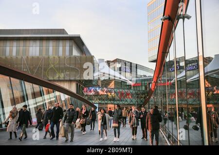 Menschen und Käufer, die zum Westfield Shopping Center laufen, Außenansicht mit Markenlogos und Schildern, Stratford, London, Großbritannien Stockfoto