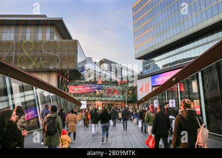Menschen und Käufer, die zum Westfield Shopping Center laufen, Außenansicht mit Markenlogos und Schildern, Stratford, London, Großbritannien Stockfoto