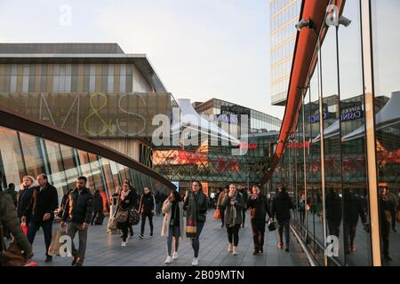 Menschen und Käufer, die zum Westfield Shopping Center laufen, Außenansicht mit Markenlogos und Schildern, Stratford, London, Großbritannien Stockfoto