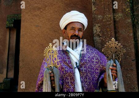 ÄTHIOPIEN, LALIBELA, UNESCO-WELTKULTURERBE, IN FELSEN GEHAUENE KIRCHE, KREUZKIRCHE, PRIESTER MIT KREUZ, NAHAUFNAHME Stockfoto