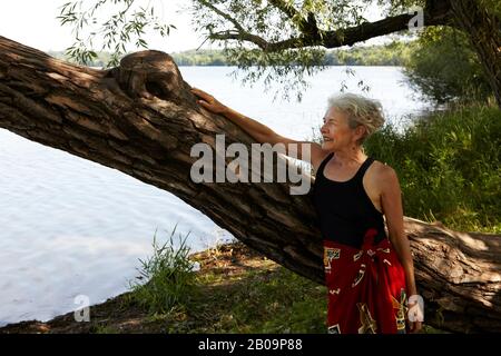 Schöne 65-jährige Frau schwimmend im See Stockfoto