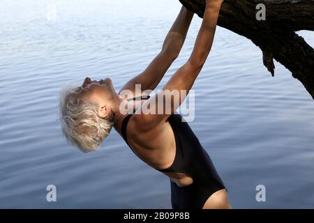 Schöne 65-jährige Frau schwimmend im See Stockfoto