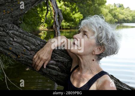 Schöne 65-jährige Frau schwimmend im See Stockfoto
