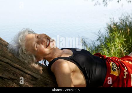 Schöne 65-jährige Frau schwimmend im See Stockfoto