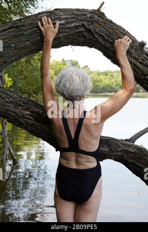 Schöne 65-jährige Frau schwimmend im See Stockfoto