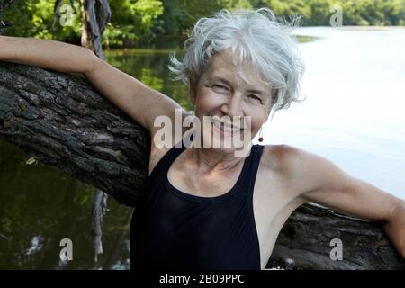 Schöne 65-jährige Frau schwimmend im See Stockfoto