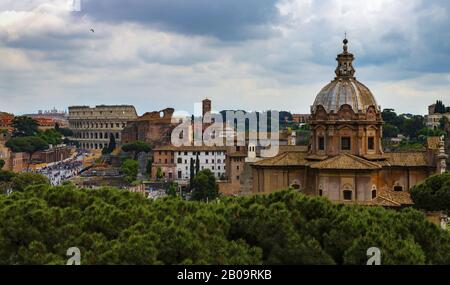 Kolosseum und Kirche in Rom unter bewölktem Himmel Stockfoto