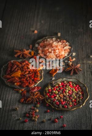 Dunkles, stimmungsvoller Foto Exotischer Gewürze auf Metallplatten. Rustikale Anordnung mit Seitenlicht. Stockfoto