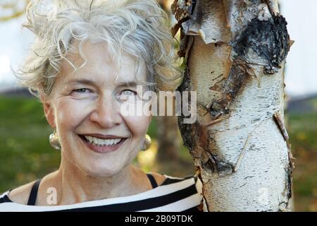 Schöne, lächelnde 65-jährige Frau Stockfoto
