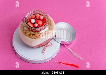 Glas mit Cremes auf pinkfarbenem Hintergrund, schönes Geschenk im März Stockfoto