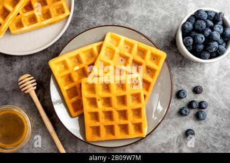 Belgische Waffeln mit Blaubeere und Honig zum Frühstück. Köstliches hausgemachtes Gebäck. Stockfoto