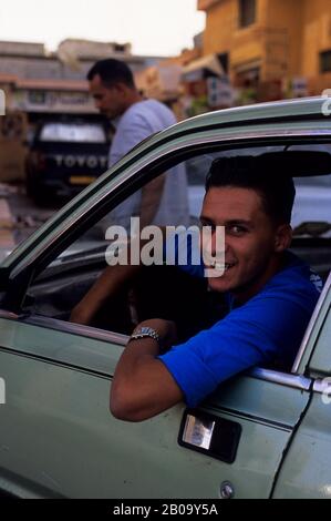 LIBYEN, IN DER NÄHE VON BENGASI, AL BAYDA, STRASSENSZENE, MAN IM AUTO Stockfoto