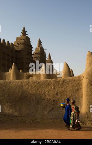 MALI, DJENNE, MENSCHEN, DIE VOR DER MOSCHEE SPAZIEREN, LEHMZIEGELBAU, WELTKULTURERBE Stockfoto