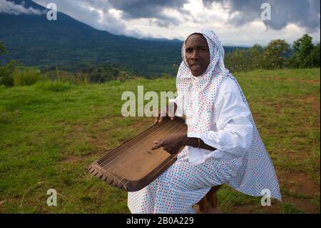 RUANDA, VIRUNGA, LOKALE TANZGRUPPE, MAN SPIELT SAITENINSTRUMENT Stockfoto