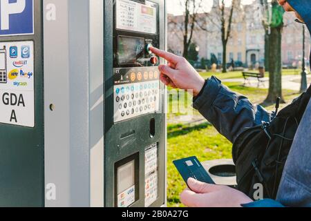 Man bezahlt für das Parken mit einer Kreditkarte mit NFS-Technologie. Einfache Zahlung. Zahlungsprozess im Automatenparkplatz. Parken im Stockfoto