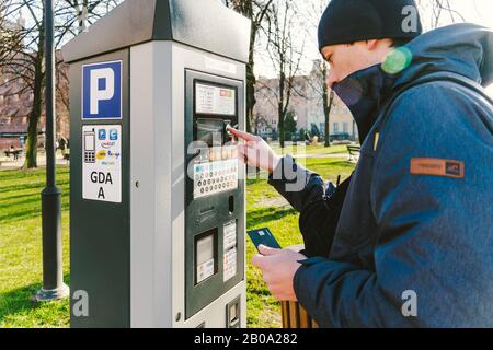 Zahlung für Parkplätze in der Stadt Danzig, Polen am 8. Februar 2020. Eine Person nutzt Monobank Kreditkarte für nfc-Zahlung im Parkterminal. Bezahlt Stockfoto