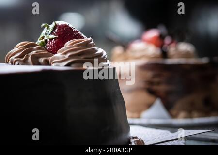 Schokoladenkuchen mit einer Erdbeere oben Stockfoto