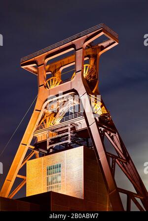 Beleuchtete Kopfbedeckung des Kohle-Bergwerks-Industriekomplexes Schacht XII am Abend, Deutschland, Nordrhein-Westfalen, Ruhrgebiet, Essen Stockfoto