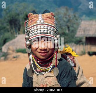 NEIN. THAILAND, IN DER NÄHE VON CHIANG RAI, LOIMI-AKHA DORF, JUNGE (BABY AUF DEM RÜCKEN) MIT TRADITIONELLER CAP, SILBER Stockfoto