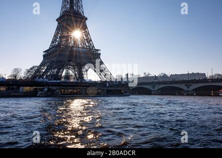 Die Sonne geht hinter dem Eiffelturm in Paris auf. Stockfoto