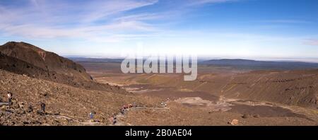 Menschen wandern durch vulkanische Landschaft am Tongariro Alpinübergang Stockfoto