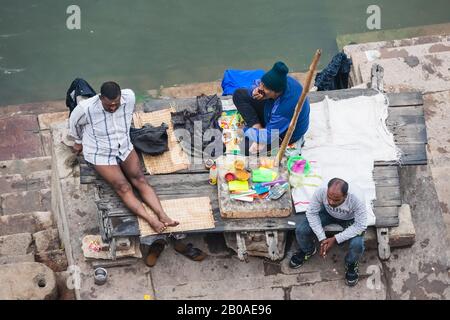Männer sitzen auf der Treppe, die zum Fluss Ganges hinabführt. Varanasi, Indien Stockfoto