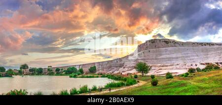 Pamukkale, Türkei - 07.14.2019. Weißer Berg und grüner See in Pamukkale. Panoramaaussicht von der Dorfseite an einem trüben Sommerabend. Stockfoto