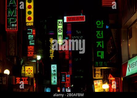 KOREA, SEOUL, EINKAUFSZENTRUM MYUNG-DONG IN DER NACHT MIT BUNTEN NEON-SCHILDERN Stockfoto