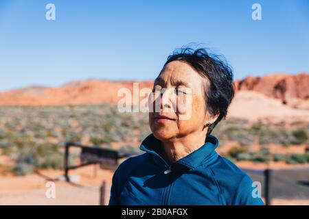 Ältere asiatische Frau in der Wüste Stockfoto