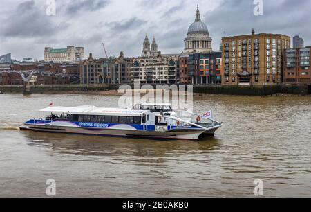 Thames Clippers 'Moon Clipper' segelt auf der Themse und startet von der Bankside Pier Station gegenüber der St Pauls Cathedral, London bei bewölktem Wetter Stockfoto