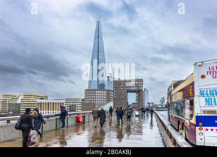 London Bridge über die Themse mit Blick auf die Shard und South Bank Dammment Gebäude an einem düsteren, nassen Wintertag mit dunklen, stürmischen Wolken Stockfoto